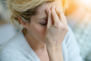 Portrait of middle-aged blond woman having a migraine