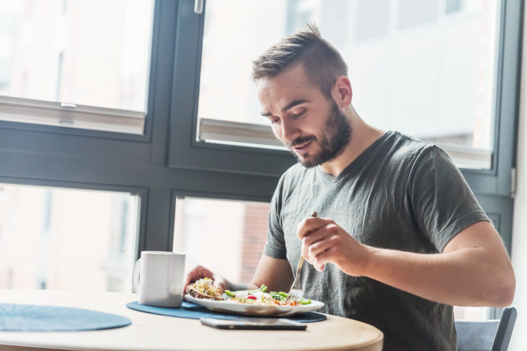 A man eating a healthy morning meal, breakfast at home. Fit lifestyle.